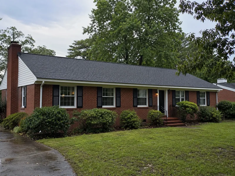Completed architectural-shingle roof on a brick ranch home